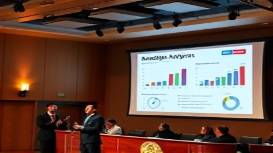 precise marketing analytics, analytical expression, presenting an infographic, photorealistic, seminar hall with a digital board, highly detailed, animated data visuals, f/5.6, bold and clear colors, spotlight lighting, shot with a 100mm lens